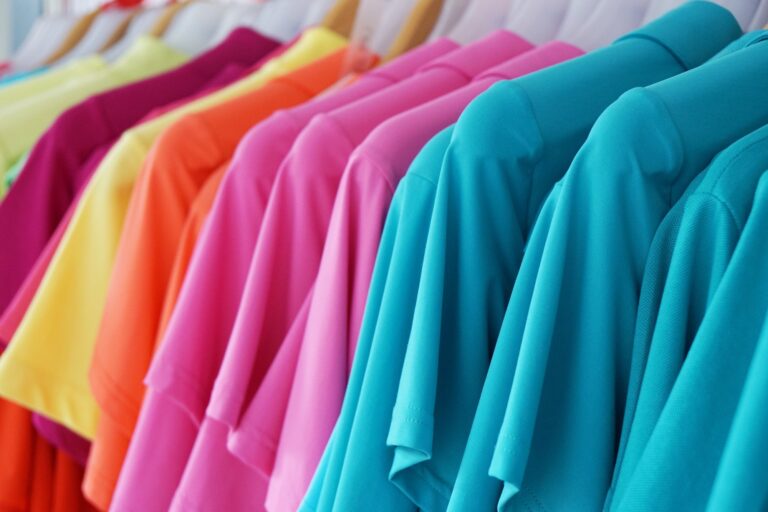 clothes rack with multicolored women's summer fashion. polo shirts, tops and blouses in vivid colors