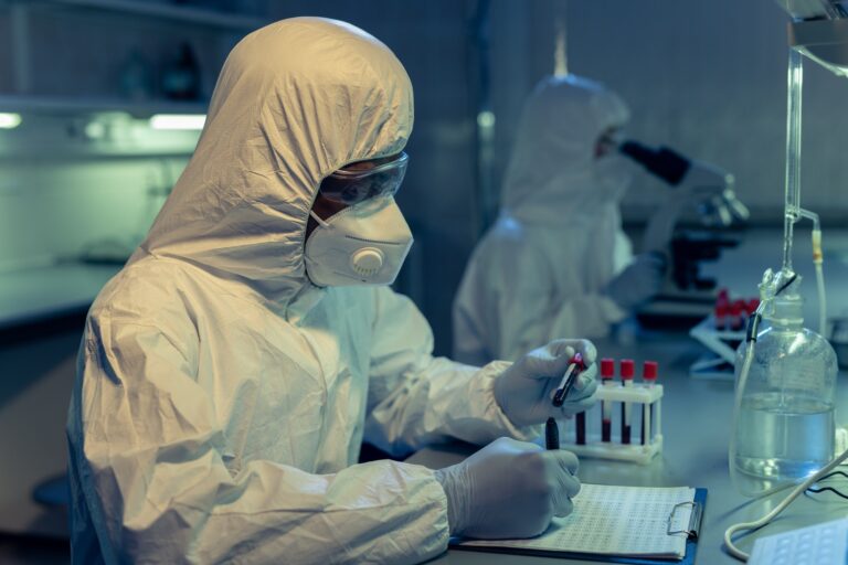 Contemporary scientist in coveralls studying one of medical samples