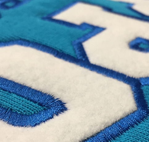 appliqué embroidery, fabric layering, decorative stitching, patchwork embroidery